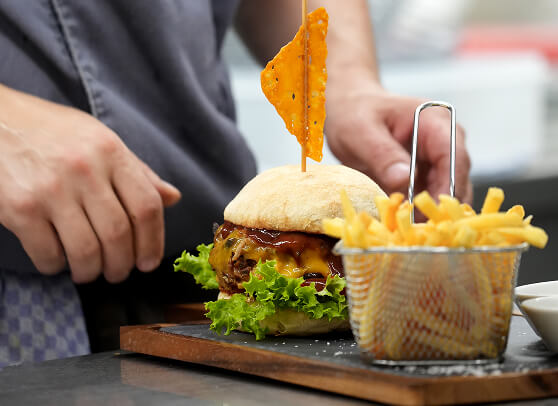 Burger mit Nacho-Chip und Pommes Frites.