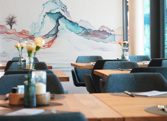 Tische, Stühle, abstraktes Wandbild im Restaurant.